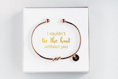 Golden personalized bridesmaid proposal bracelet with a initial charm in a box that says "I couldn't tie the knot without you"  